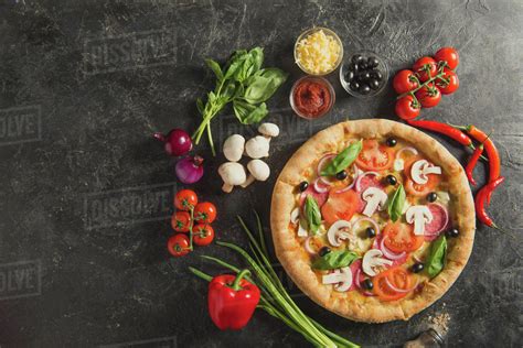 Flat Lay With Italian Pizza And Fresh Ingredients On Dark Surface