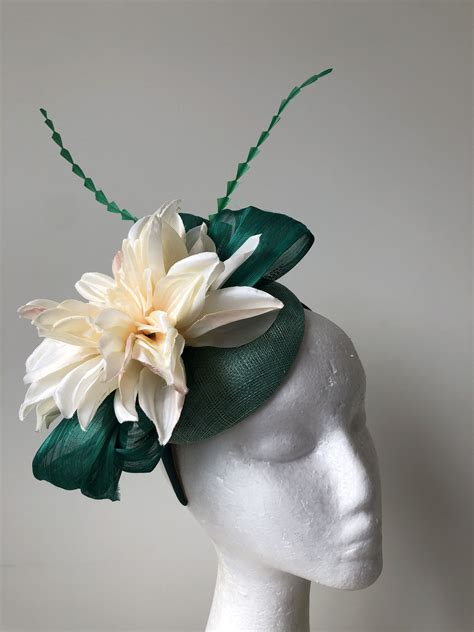 Green Fascinator With Loops Feathers And Cream Flower On A Green