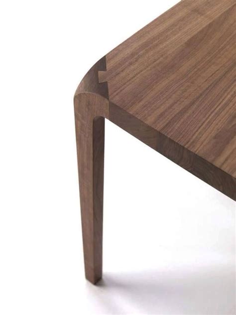 A Close Up Of A Wooden Table With One Leg Bent Back And The Other End