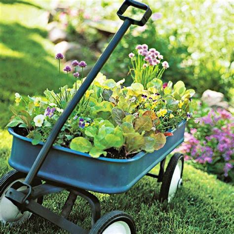 A Blue Wheelbarrow Filled With Flowers And Plants