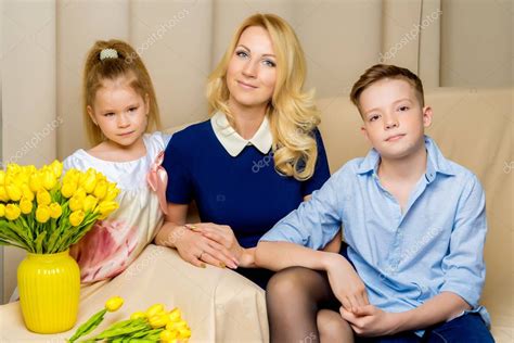 Mom And Son And Daughter Are Sitting On The Couch In The Studio