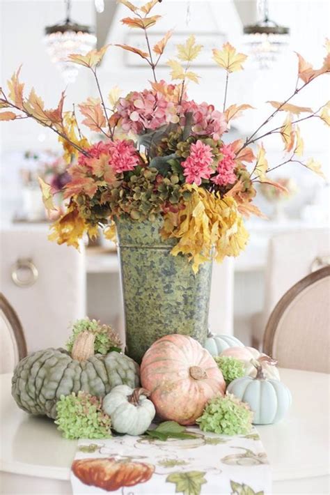 A Vase Filled With Flowers Sitting On Top Of A Table Next To Pumpkins