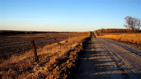 An Old Dirt Country Back Road In Kansas Runs Along The Farm Landscape