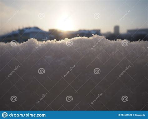 Sunset In The Winter Snow And Snowflakes City Skyline Houses And