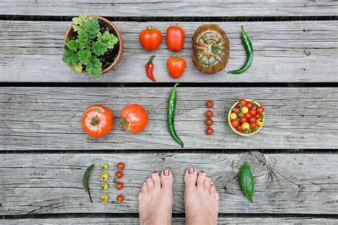 Woman S Feet With Garden Harvest On Wooden Background By Stocksy Contributor Holly Clark