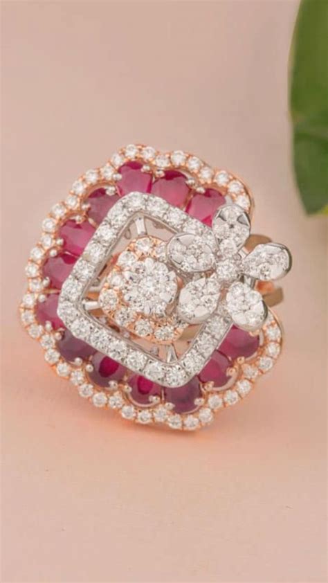 A Pink And White Diamond Ring Sitting On Top Of A Table Next To A Green