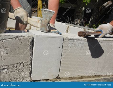 Bricklayer Builders Laying Autoclaved Aerated Concrete Blocks For House
