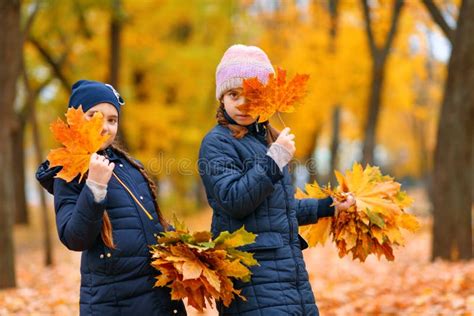 Girls Playing And Posing In Autumn City Park Two Children Plays With