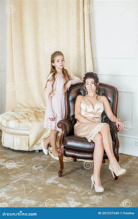 Lovely And Elegant Mother And Daughter In Beautiful Fashionable Dresses With Hairstyles In A