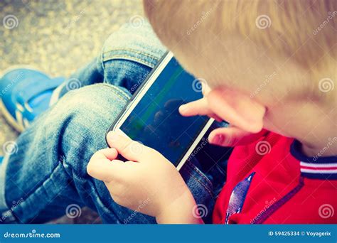 Little Boy Child Playing Games On Mobile Phone Outdoor Stock Photo