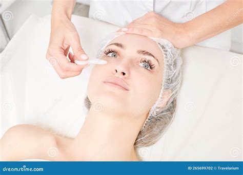 Beautician Making Facial Massage With Gua Sha Stone Of Woman Face Skin For Lymphatic Drainage