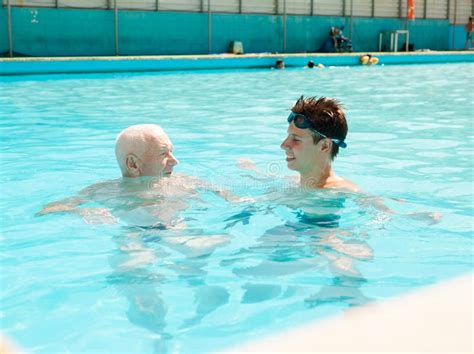 Sports Grandfather And Grandson Communicate In Swimming Pool Stock
