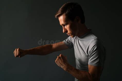 Side View Of Young Handsome Man Making Punches Low Key Photography