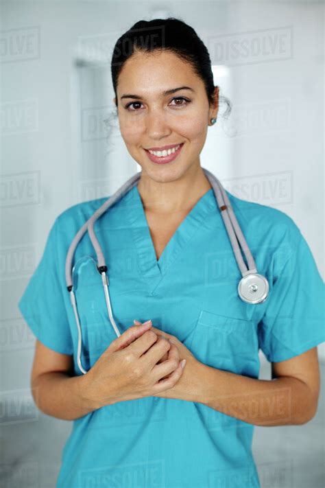 Smiling Hispanic nurse in scrubs - Stock Photo - Dissolve