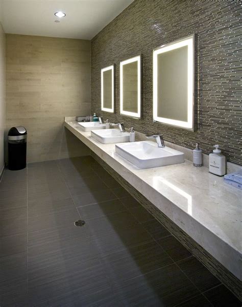 a bathroom with two sinks and three mirrors