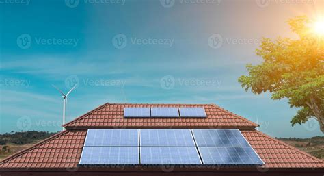 painel solar no telhado de uma casa com turbinas eólicas ao redor
