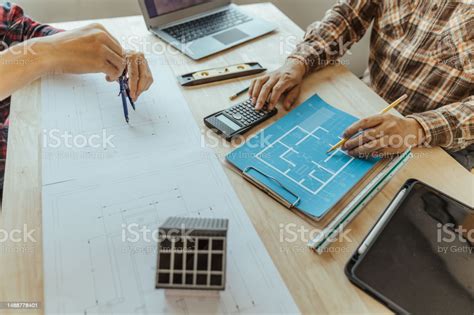 Architect Designing House Examining House Plans Customer Assigned