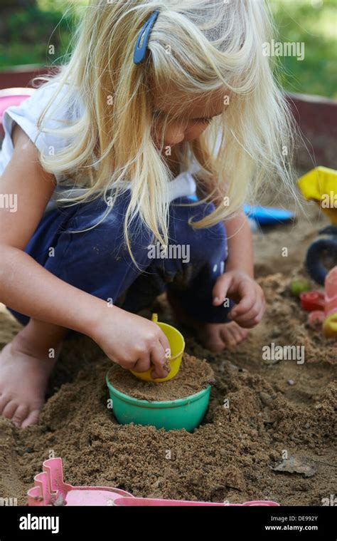 Little Blond Girl Playing In Sandpit At Summer Garden Stock Photo Alamy