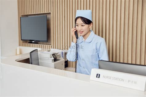 Female Nurse Answering Phone At Nurse Desk In Hospital Picture And Hd