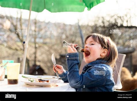 Cute Girl Eating Sausages During Spring Day In The Yard Stock Photo Alamy