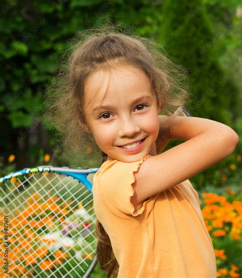 Portrait Of Cute Little Girl Playing Tennis In Summer Stock Photo