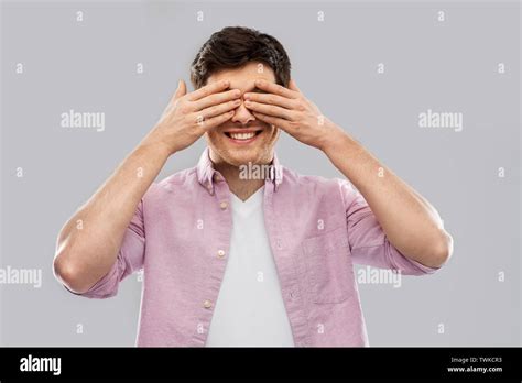Man Closing His Eyes By Hands Over Grey Background Stock Photo Alamy