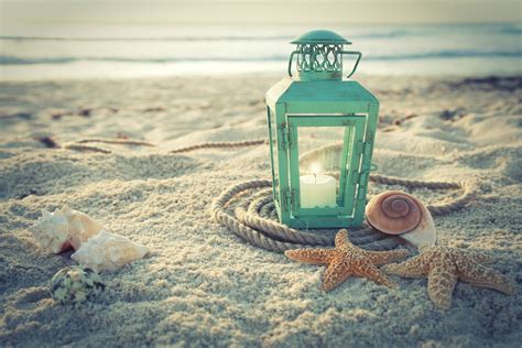 Cross Processed Lantern On Beach With Shells And Rope At Sunrise The