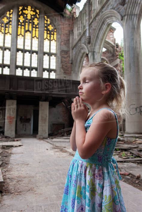 Little Girl Praying In Ruined Church Stock Photo Dissolve