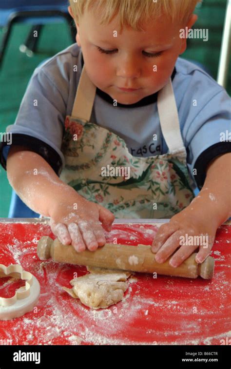 Child Rolling Out Pastry Using A Rolling Pin Stock Photo Alamy