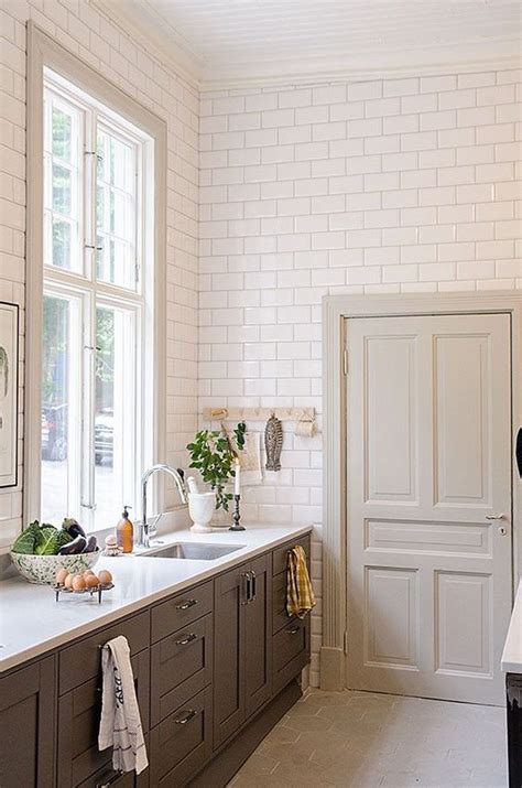 Continue removing all the tiles to expose the countertop. Floor to ceiling subway tile. Large windows. Bottom ...