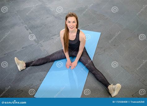 Fitness Woman Stretching Legs Sitting On Gym Mat Soirt And Healthy