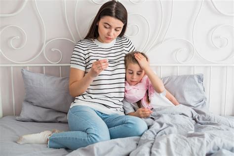 Madre Cuidando De Su Hija Enferma Foto Gratis