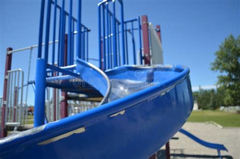 Colourful Playground Slide In School Yard With School In Background