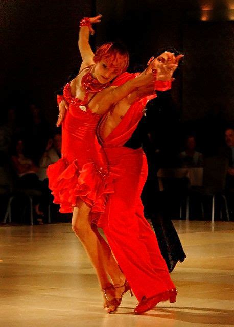 Two People In Red Dresses Dancing On A Dance Floor