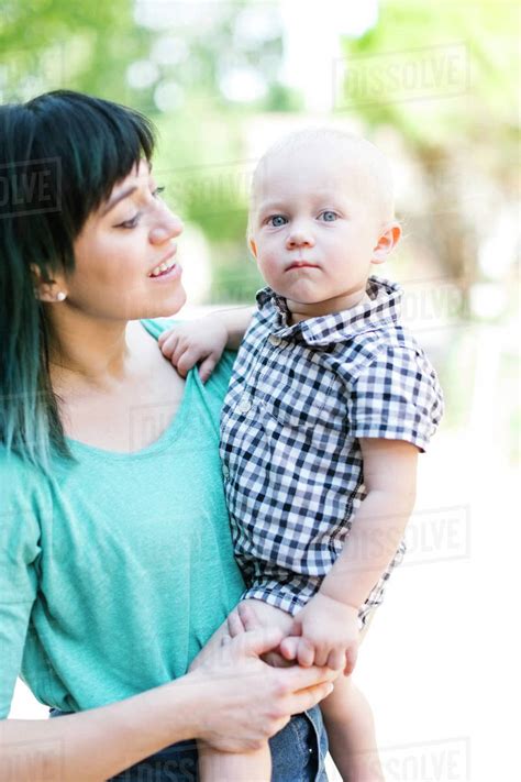 Mother Carrying Baby Boy Stock Photo Dissolve