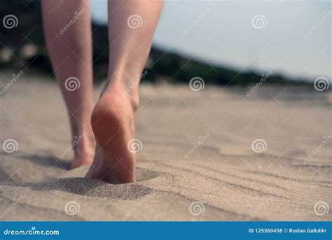 Босые ноги женщин идя на песок на пляже морем Стоковое Фото изображение насчитывающей лоток