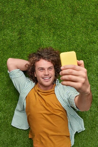 Premium Photo Smiling Guy Taking Selfie On Grass