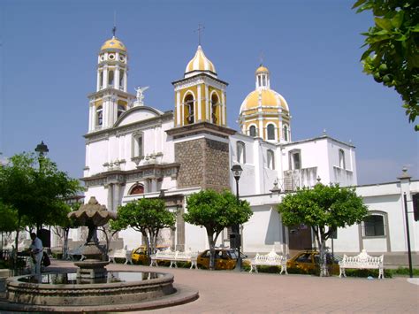 A Large White Building With Two Yellow Domes On Its Sides And Trees In