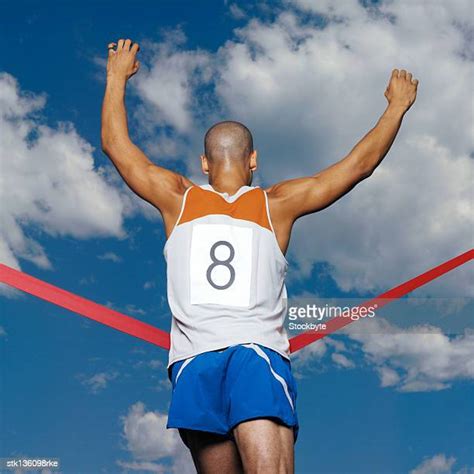 Male Runner Crossing Finish Line Photos And Premium High Res Pictures