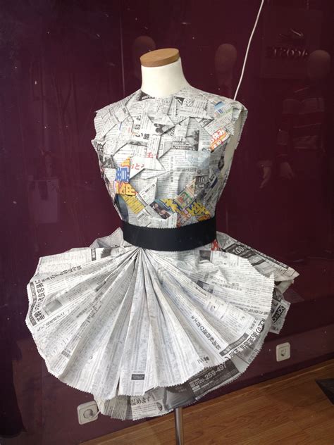 A Dress Made Out Of Newspapers Sitting On Top Of A Mannequin