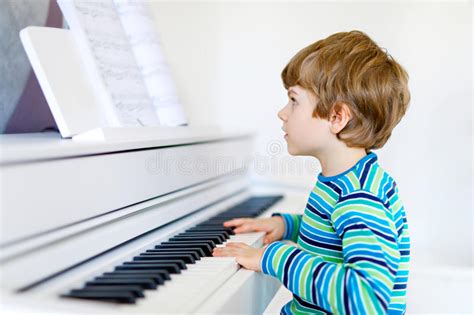 Beautiful Little Kid Boy Playing Piano In Living Room Or Music School