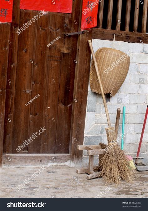 Traditional Chinese Broom And Dustpan By The Wooden Door Stock Photo