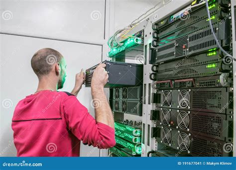 Senior Engineer Takes The Server Out Of The Rack With Computer