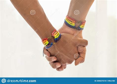 Close Up Shot Of Asian Male Couple Holding Hands With Gay Pride Rainbow Awareness Wristbands