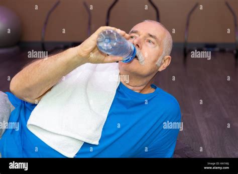 Elderly Man Drinking Water During Break On The Gym Stock Photo Alamy