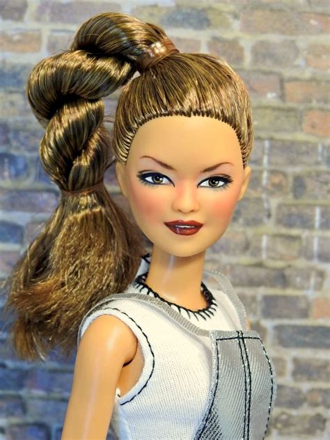 A Doll With Long Hair Wearing A White Top