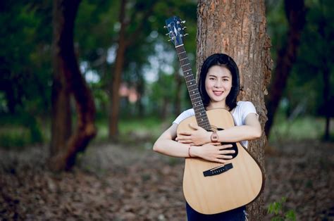 Premium Photo Woman With Her Guitar Singing In Nature