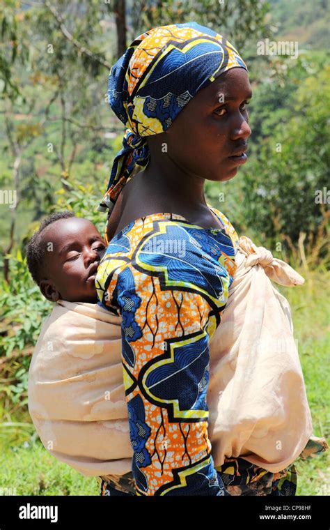 A Woman Carries Her Baby On Her Back In The Traditional Manner In