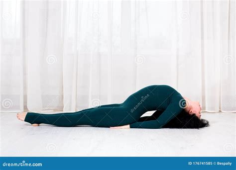 Girl In Sportswear Doing Yoga Exercises With Arching Of The Back In The Room Stock Image