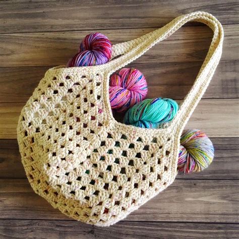 A Crocheted Bag With Balls Of Yarn In It On A Wooden Floor Next To A